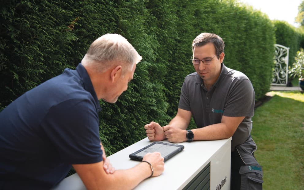 Installatør og Vaillant-servicetekniker installerer en varmepumpe.